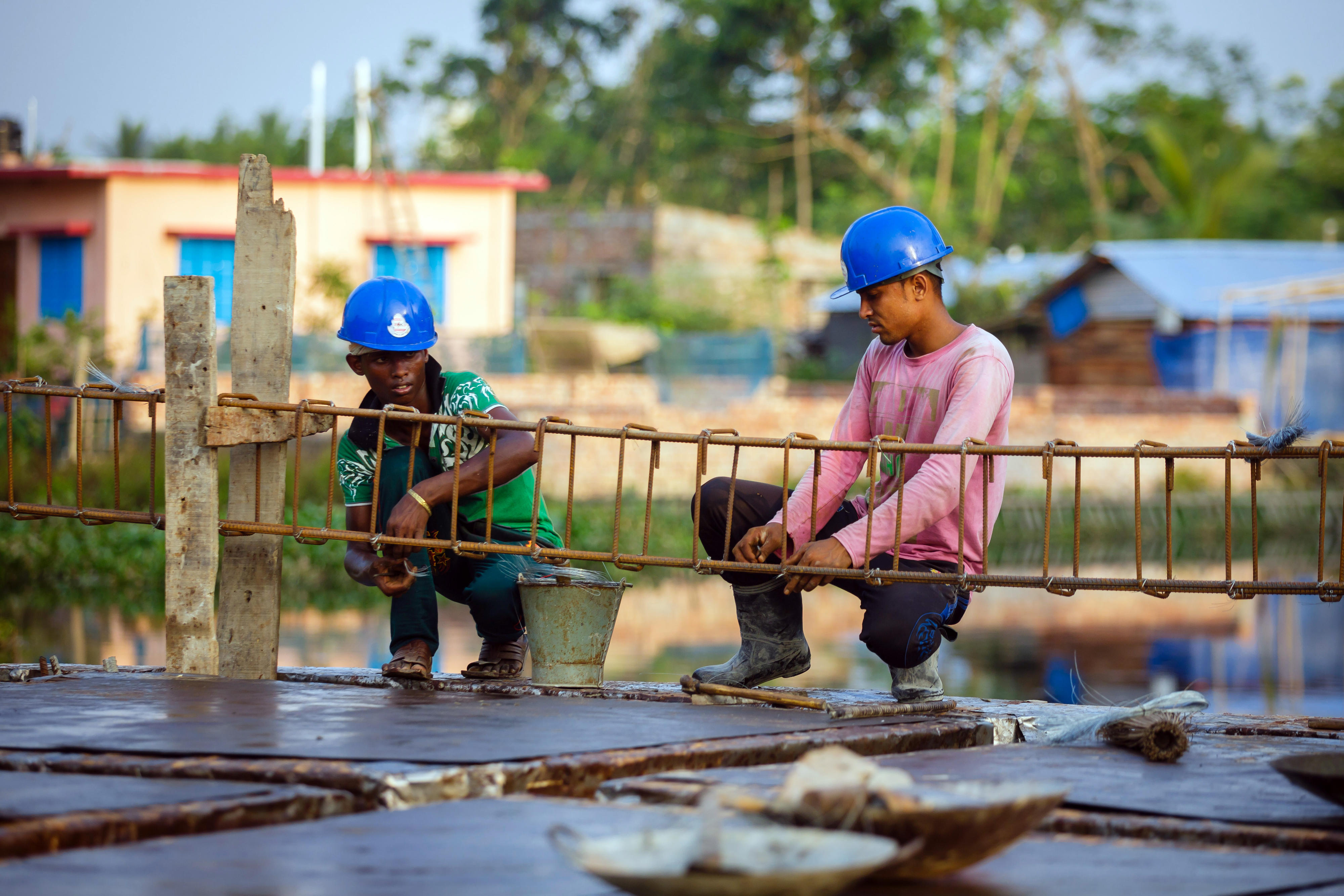 Two workers at a construction site on the banks of the Mayur River in Khulna town working on a bank stabilisation.