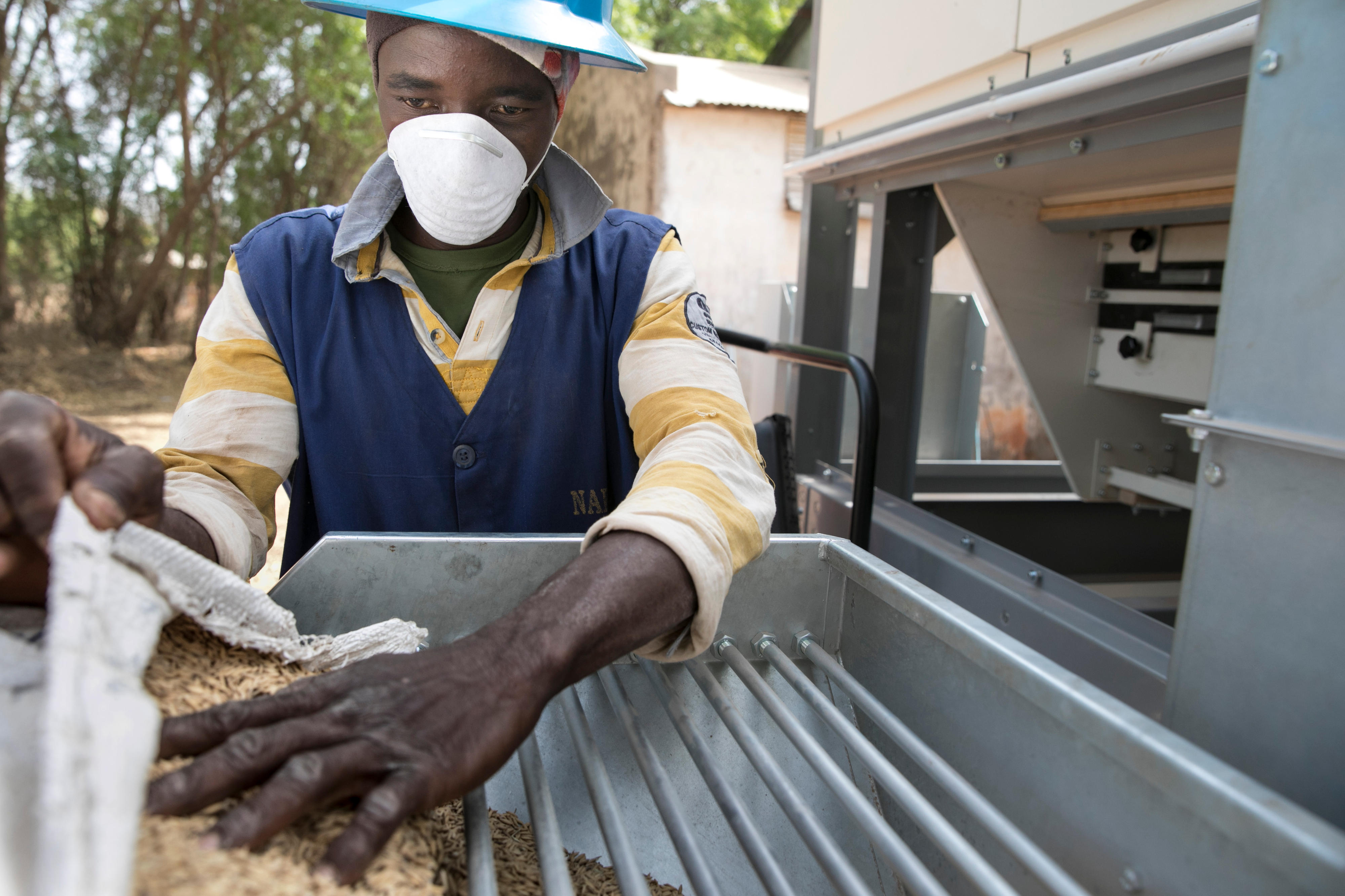 Auszubildender an einer Maschine zur Gewinnung von Saatgut im Grünen Innovationszentrum in Burkina Faso