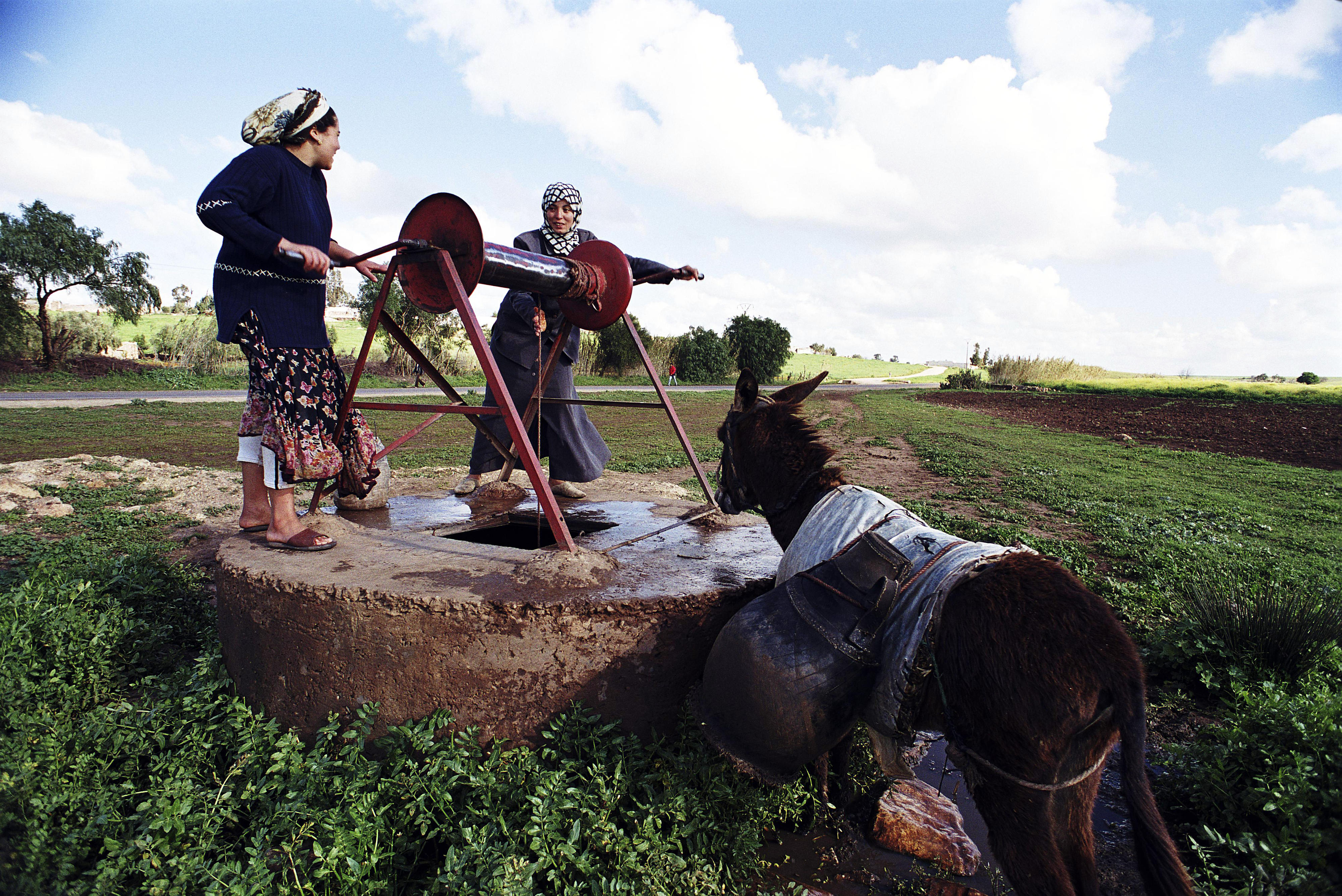 Frauen holen Wasser an einem Brunnen in Marokko.