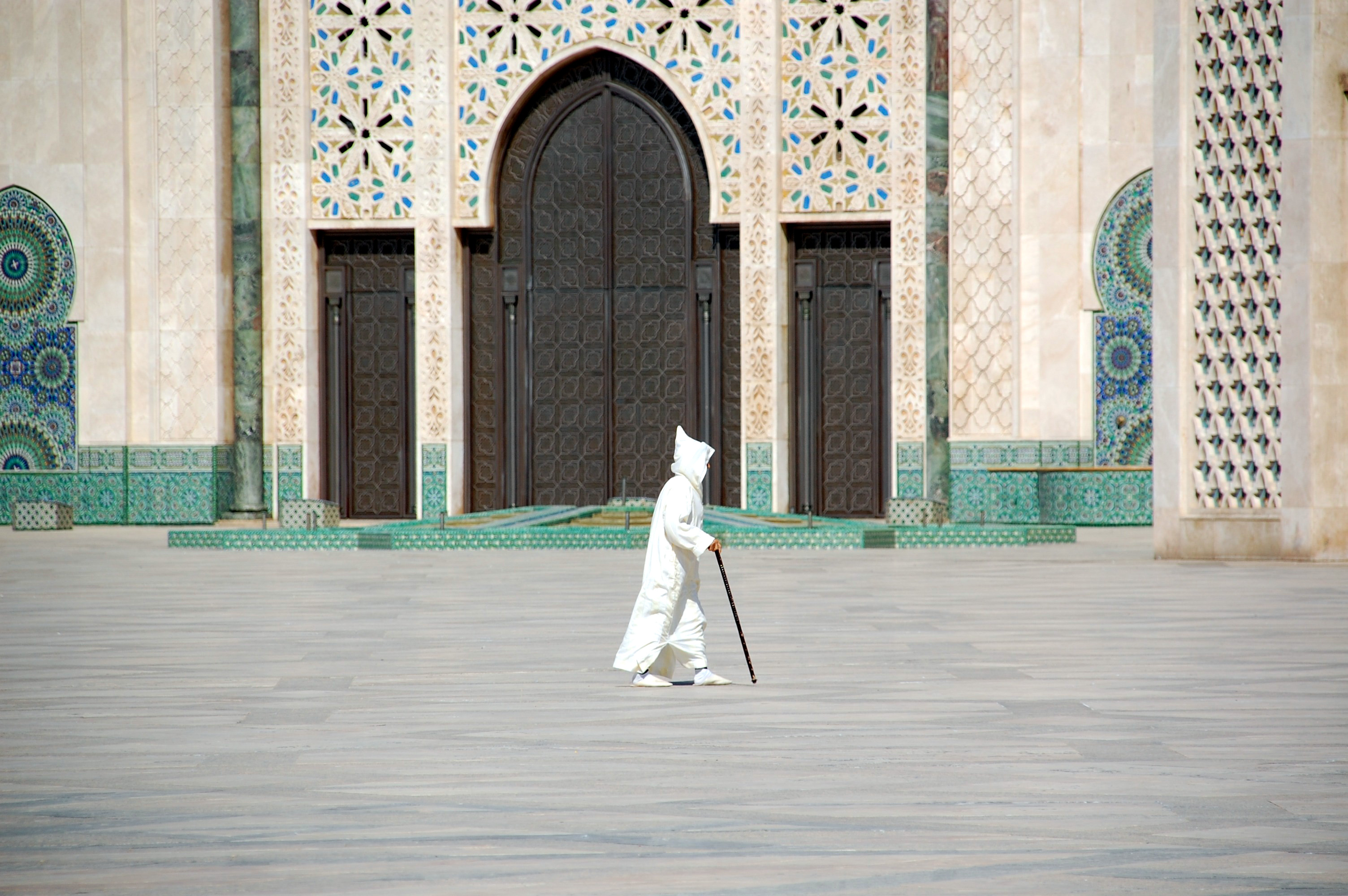 Ein Mann geht über einen Platz vor einer Moschee in Casablanca, Marokko