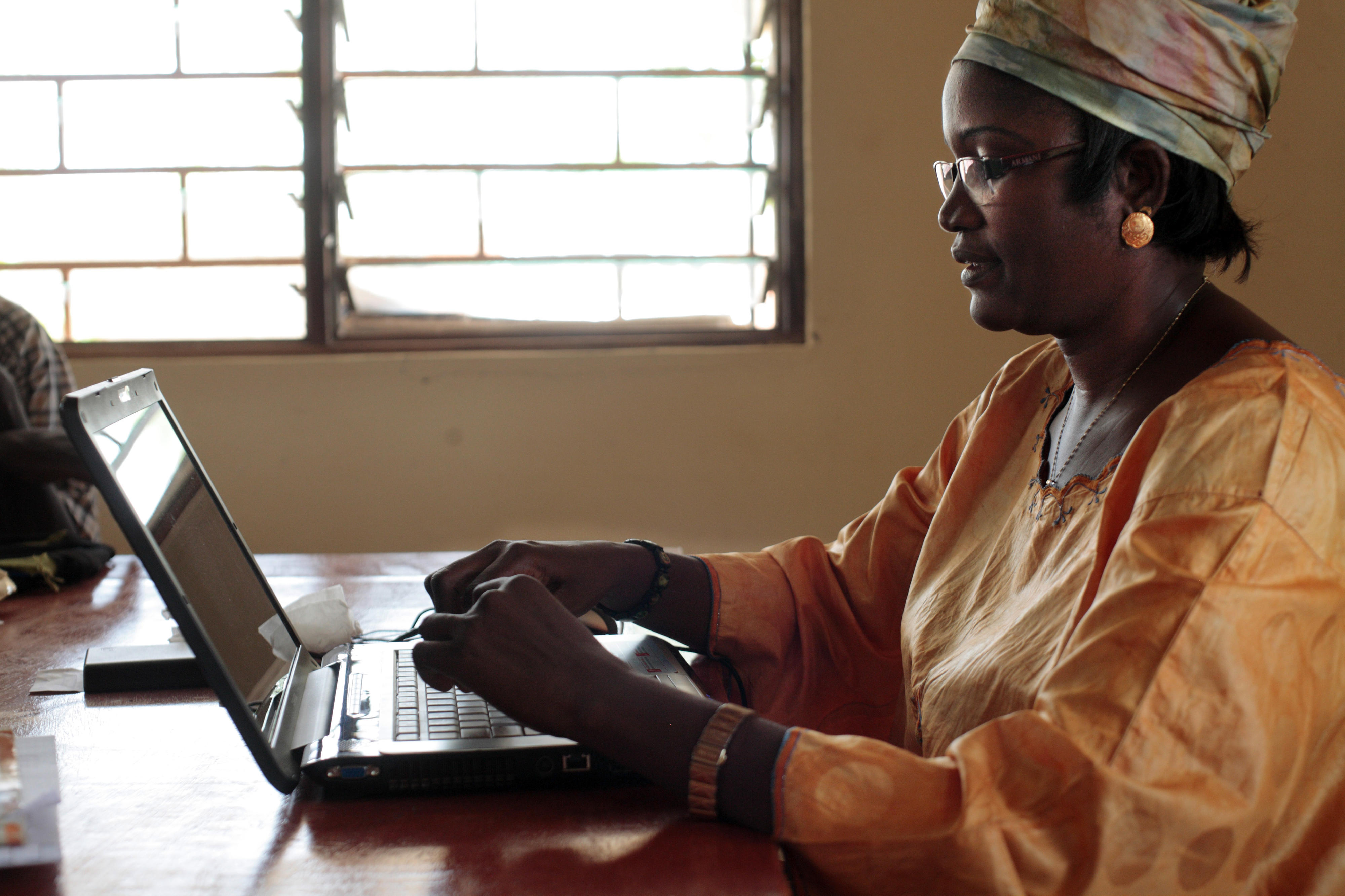 Eine Frau in Burkina Faso arbeitet an einem Laptop.