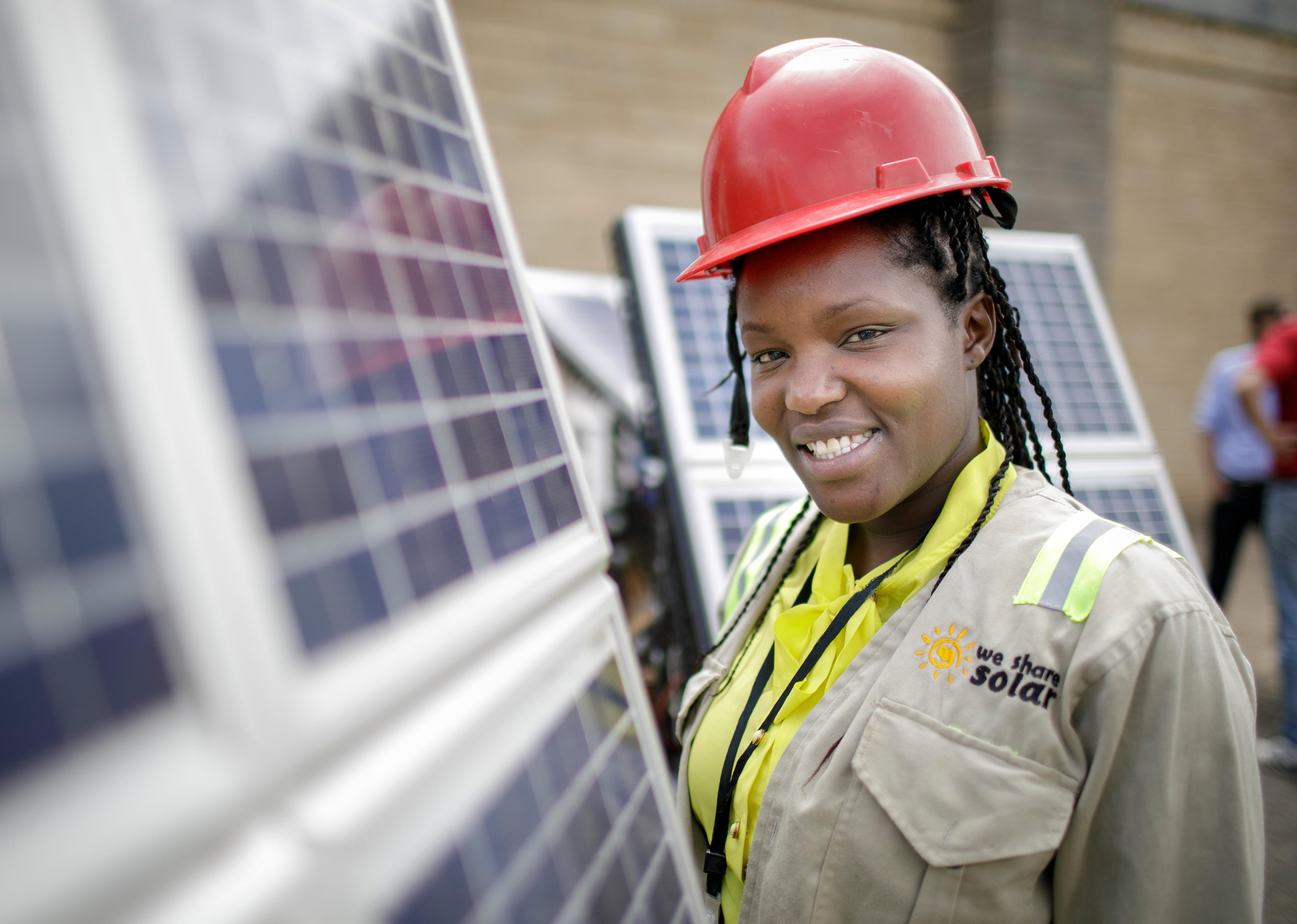Studentin neben Solaranlagen in einer Ausbildungseinrichtung für Solartechniker und Energieauditoren an der Strathmore University, Nairobi