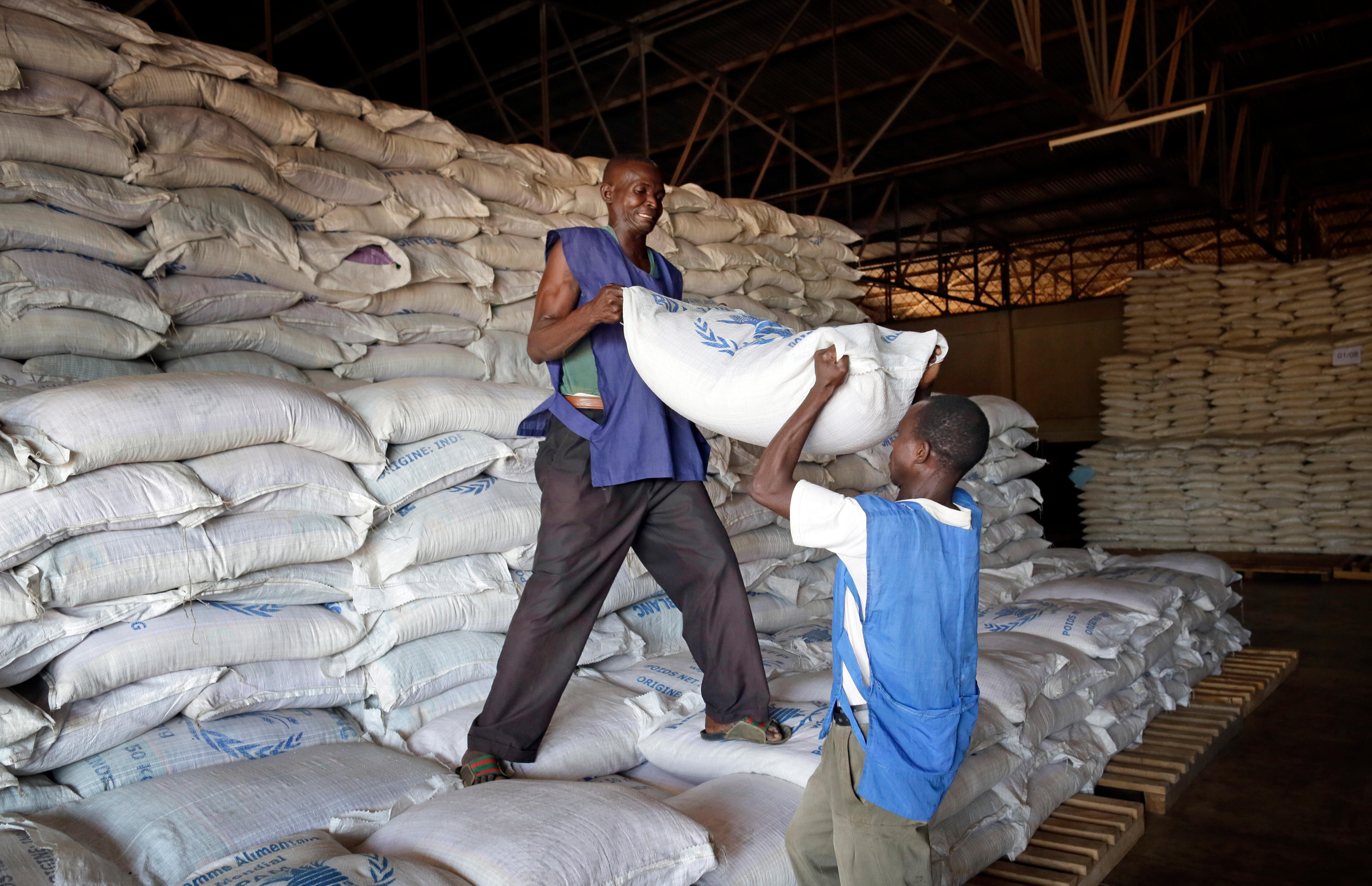 Mit­ar­bei­ter des Welt­ernäh­rungs­pro­gramms ver­la­den Le­bens­mit­tel an ei­nem Lo­gis­tikstütz­punkt in der Zen­tral­afri­ka­ni­schen Re­pu­blik.