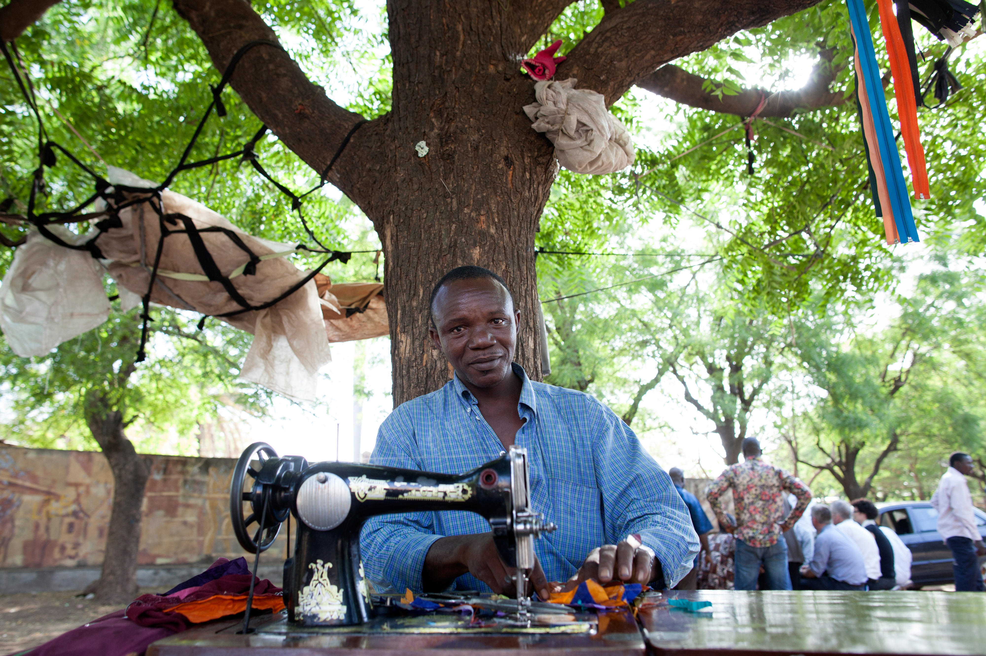 Schneider an einer Nähmaschine auf einer Straße in Bamako, Mali