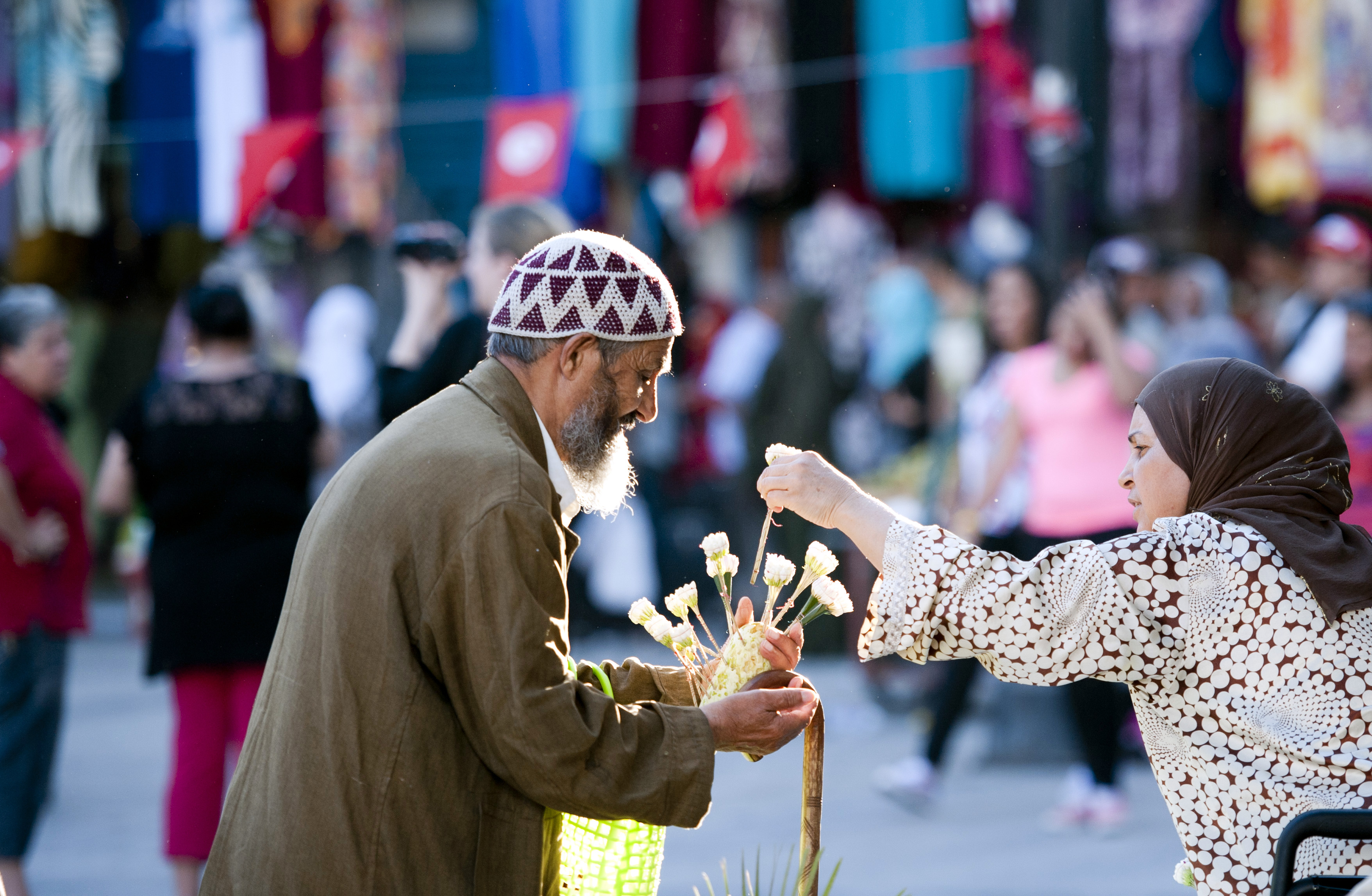 A man sells flowers to a passer-by in the old town of Tunis.