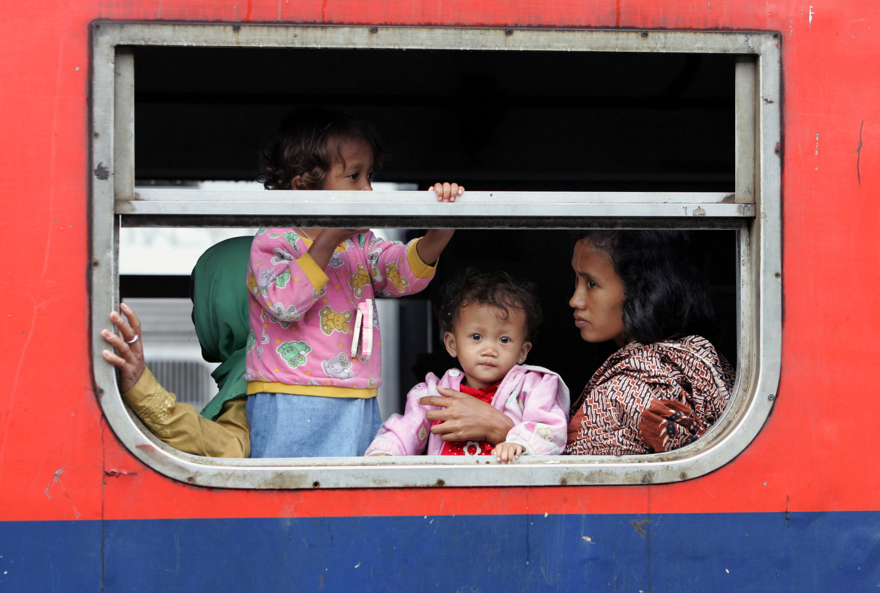 Mother with her children in a train compartment, Jakarta, Indonesia