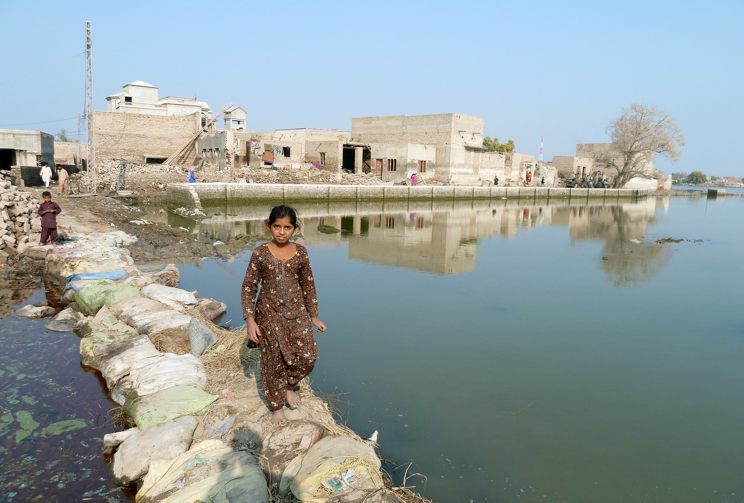 Ein junges Mädchen auf einer Behelfsbrücke nach einer Überflutung in der Provinz Sindh in Pakistan