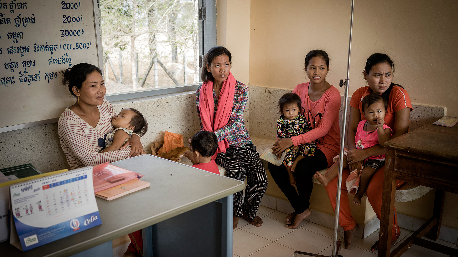 Mothers and children participating in a growth study are waiting in a waiting room in Prey Veng, Cambodia.