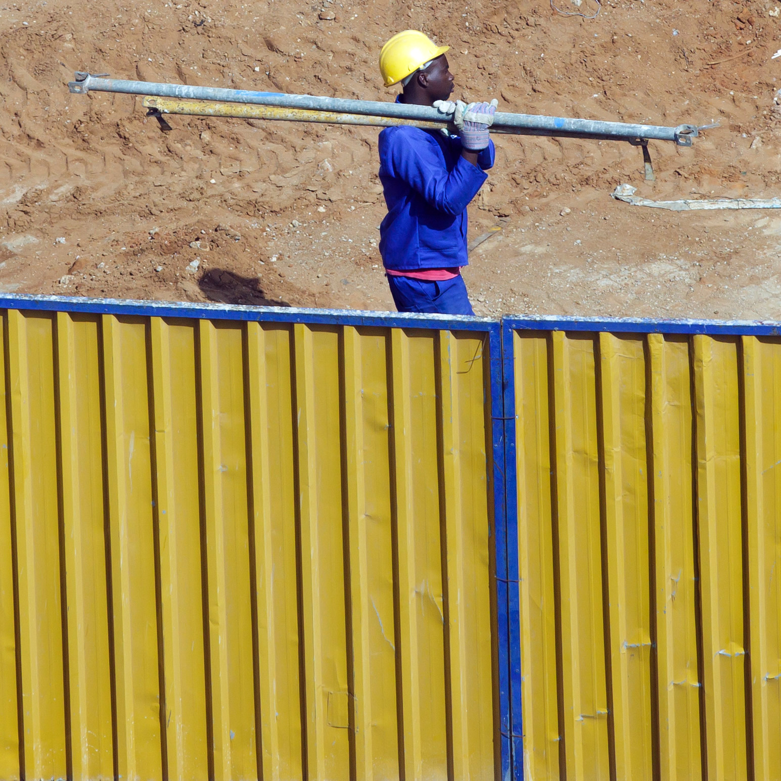 A construction worker carries steel pipes across a construction site in Mozambique's capital Maputo.