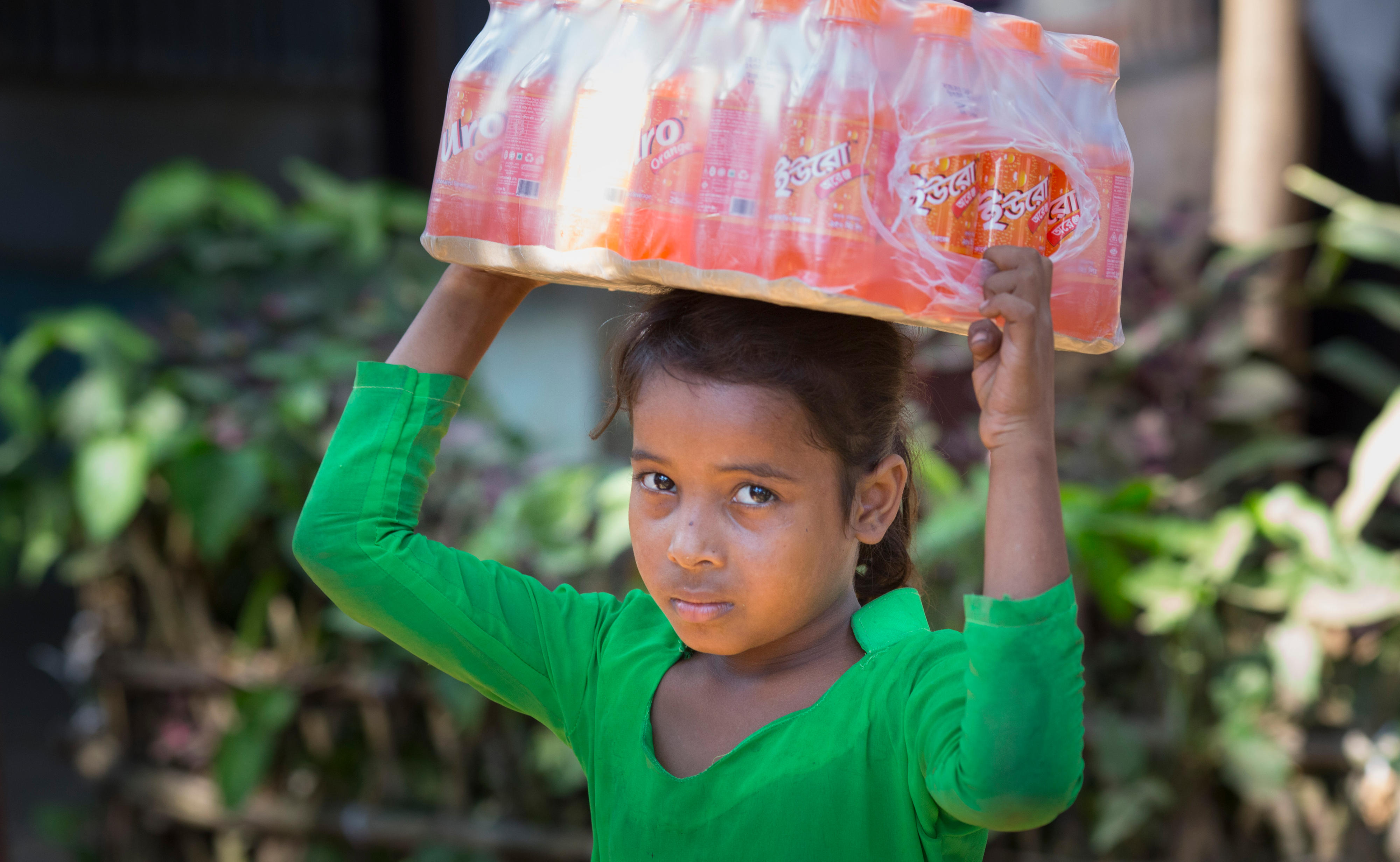 Flüchtlingslager Kutupalong, in dem Rohingya, die aus Myanmar vertrieben wurden, leben: Ein Mädchen trägt eine Palette mit Getränken auf ihrem Kopf.