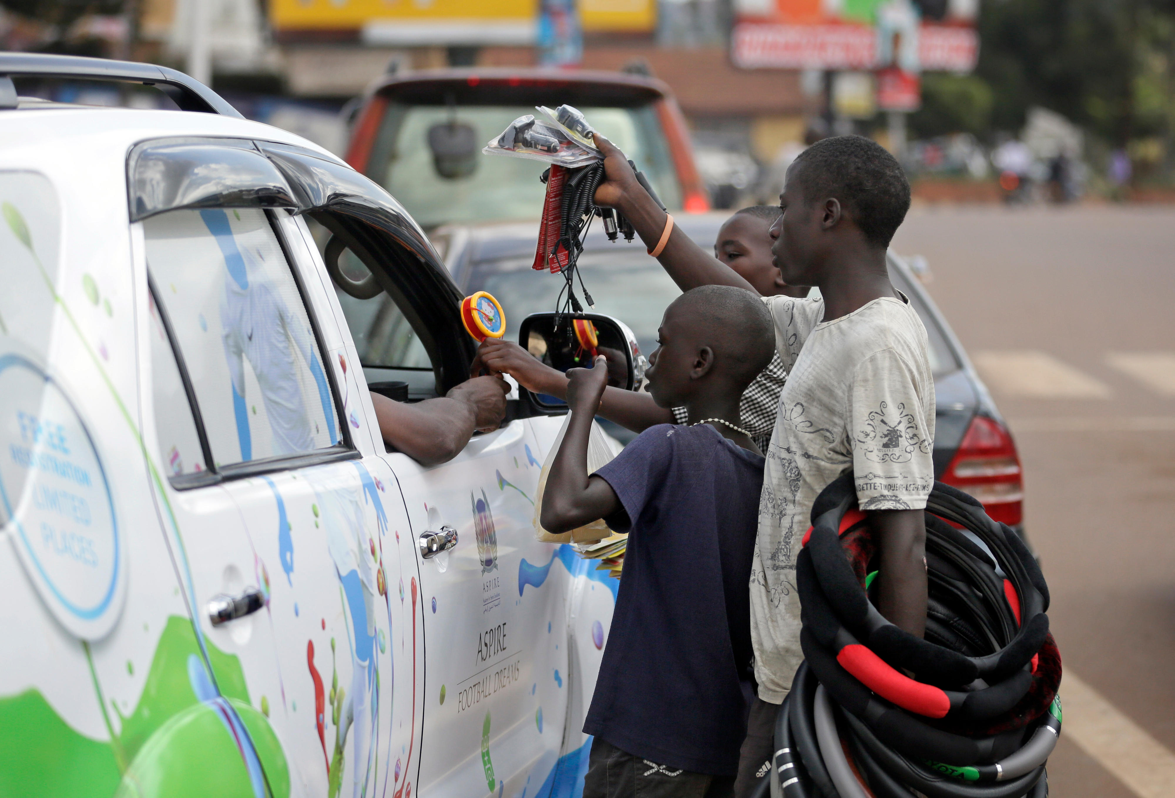 Kinder in Kampala, Uganda, versuchen, Waren an Autofahrer zu verkaufen.