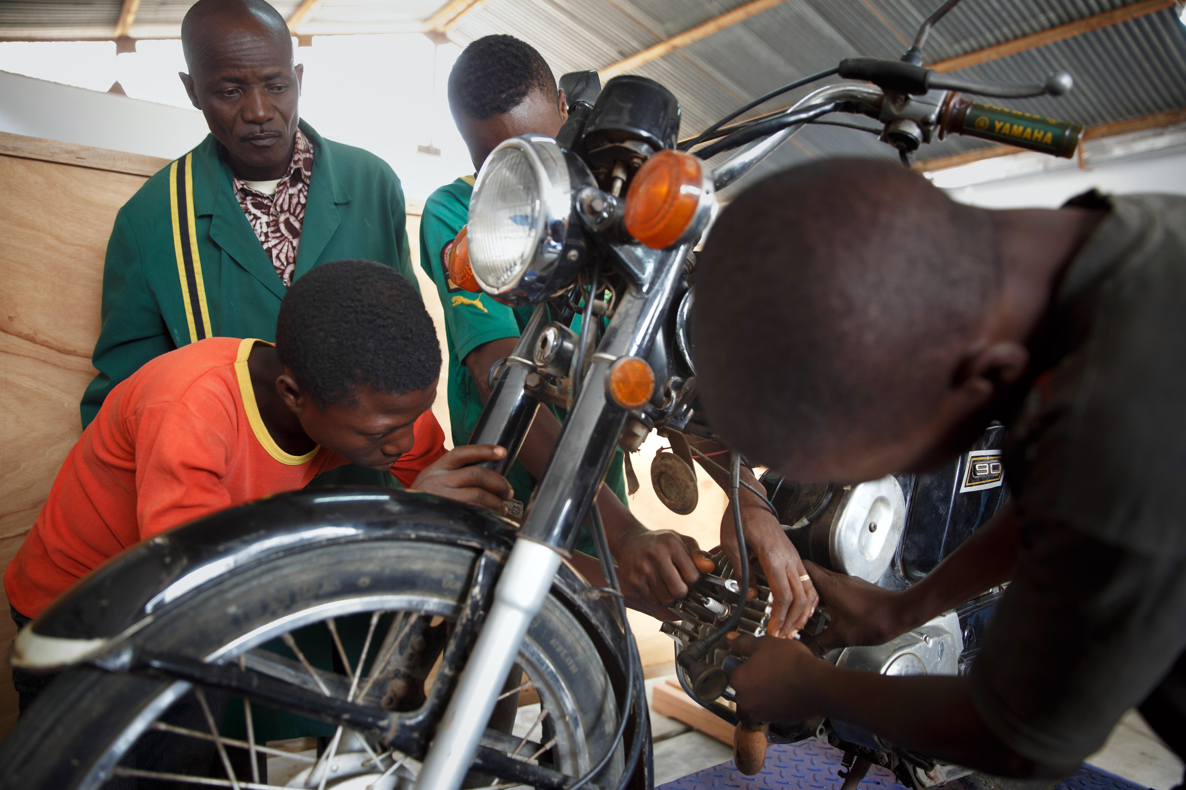 Vocational students enrolled in a motor vehicle mechanics course at a vocational school in Sokodé, Togo, are repairing a motorcycle.