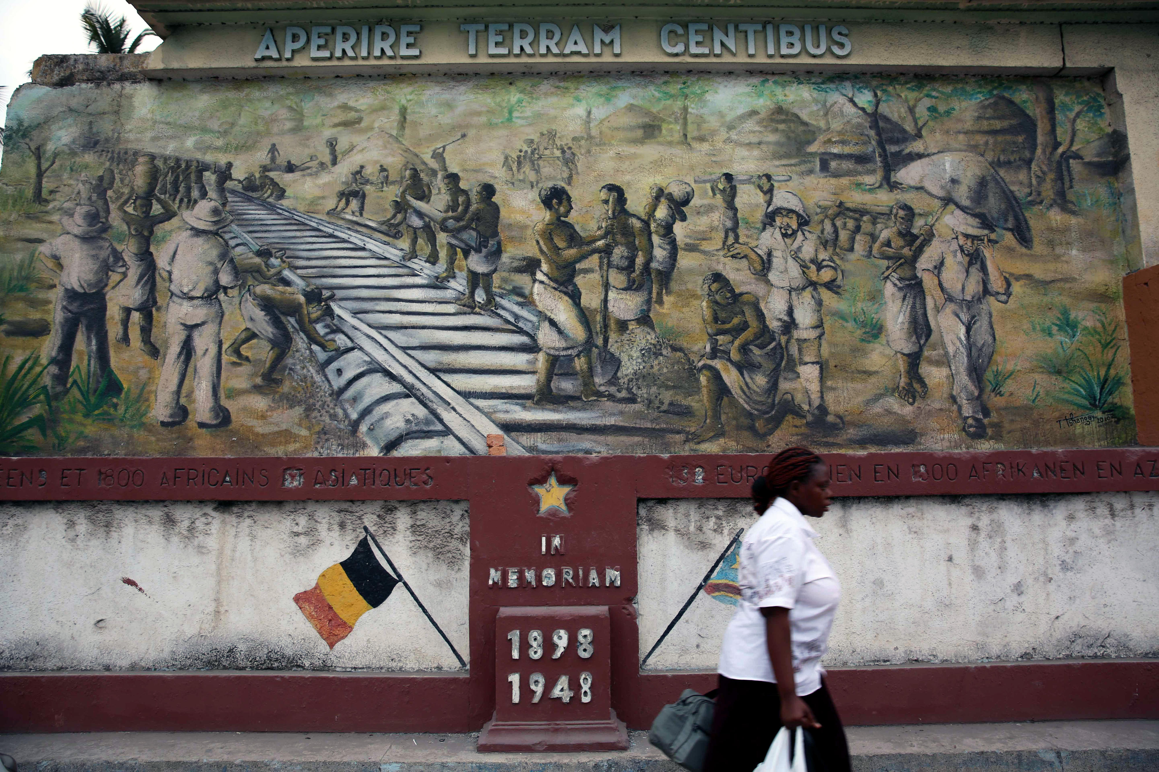 A woman in front of a mural at the railway station of Kinshasa, the capital of the DR Congo.