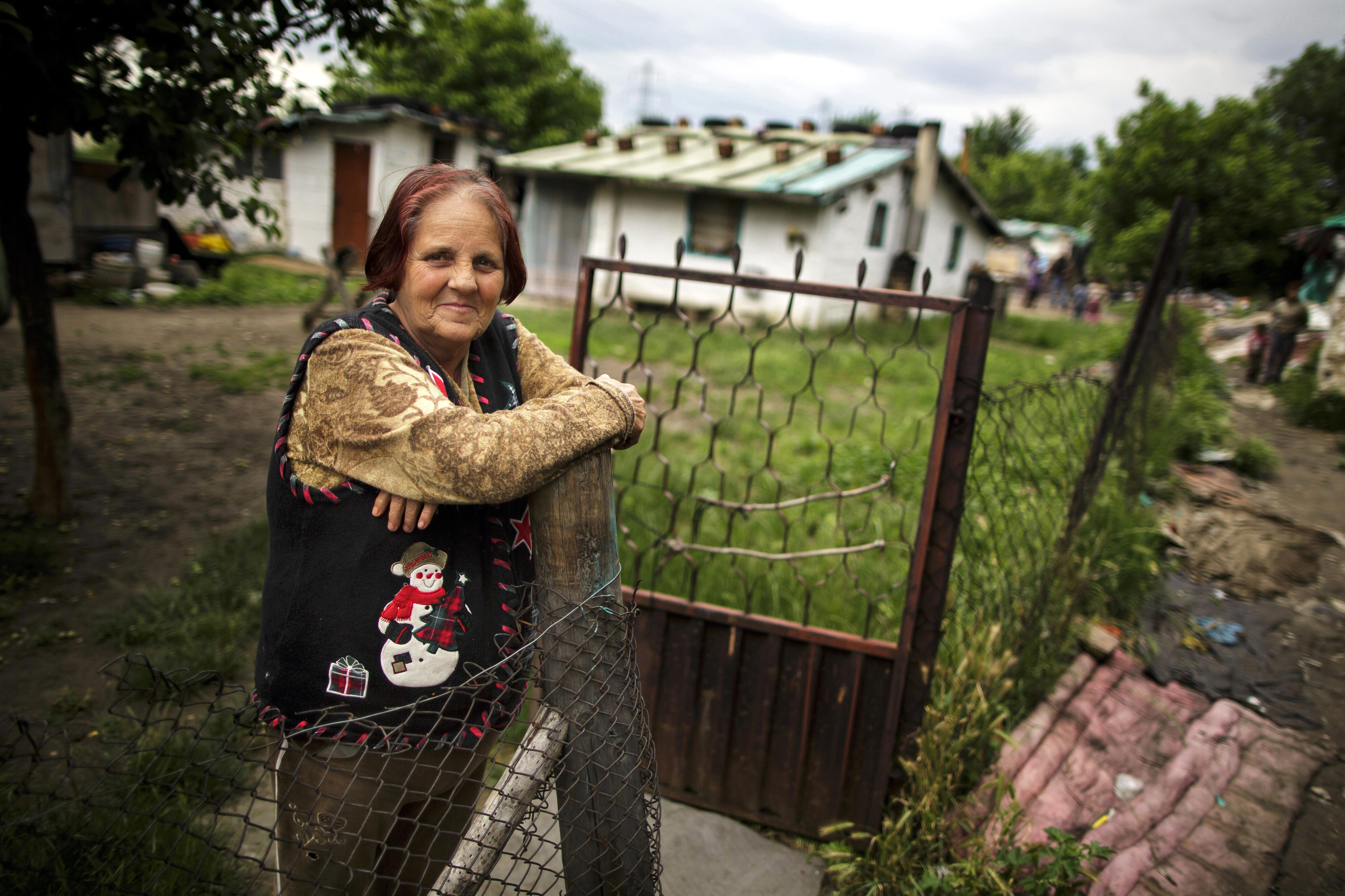 A woman stands at the fence of her property in a Roma settlement in Belgrade.