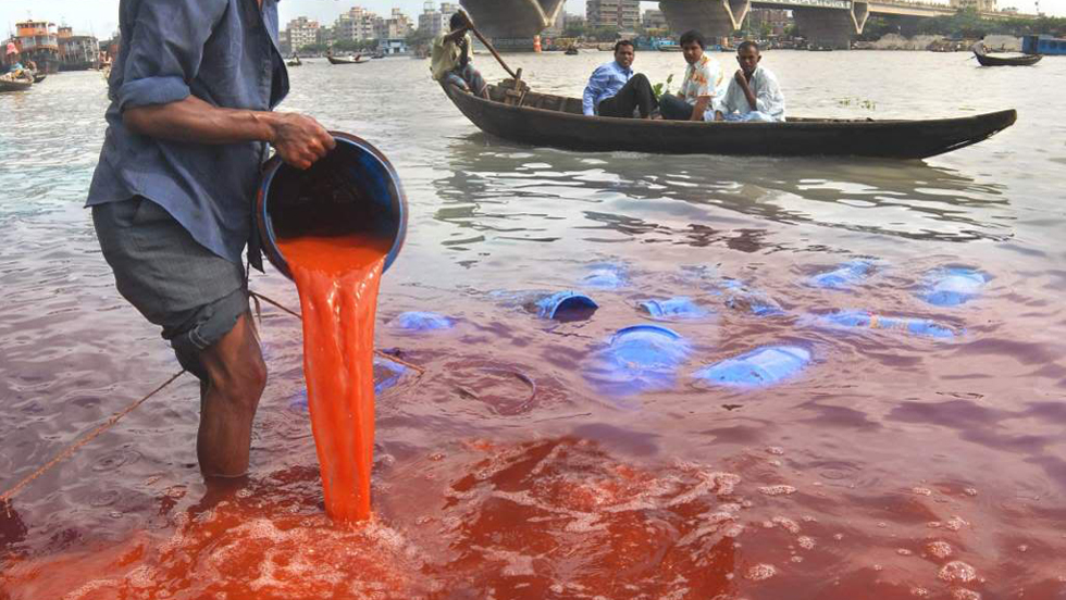 Rote Farbe aus der Textilindustrie wird in einen Fluss in Bangladesch geschüttet.