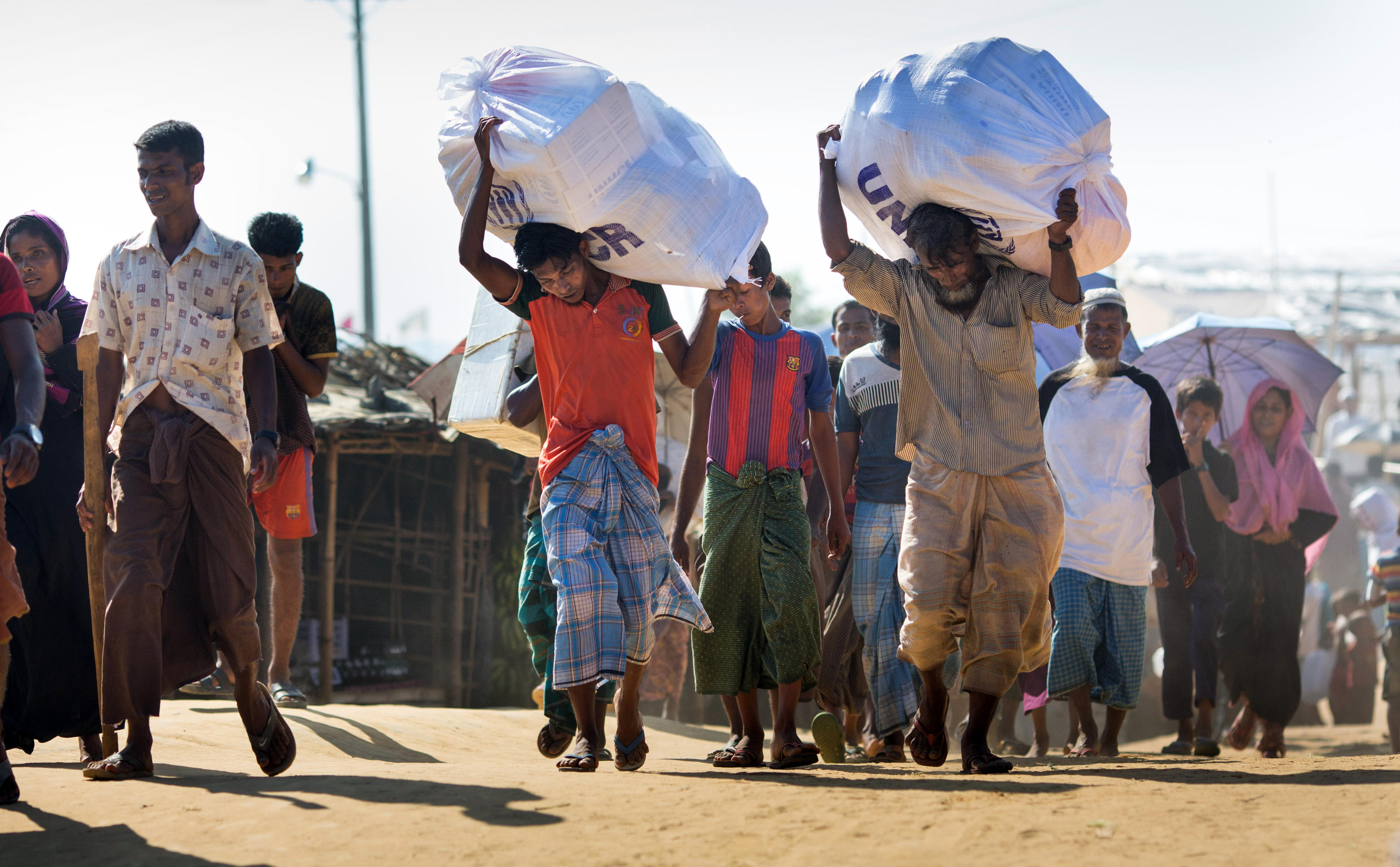 Männer mit Hilfsgütern des UNHCR im Flüchtlingslager Kutupalong in Bangladesch, in dem Rohingya , die aus Myanmar vertrieben wurden, leben