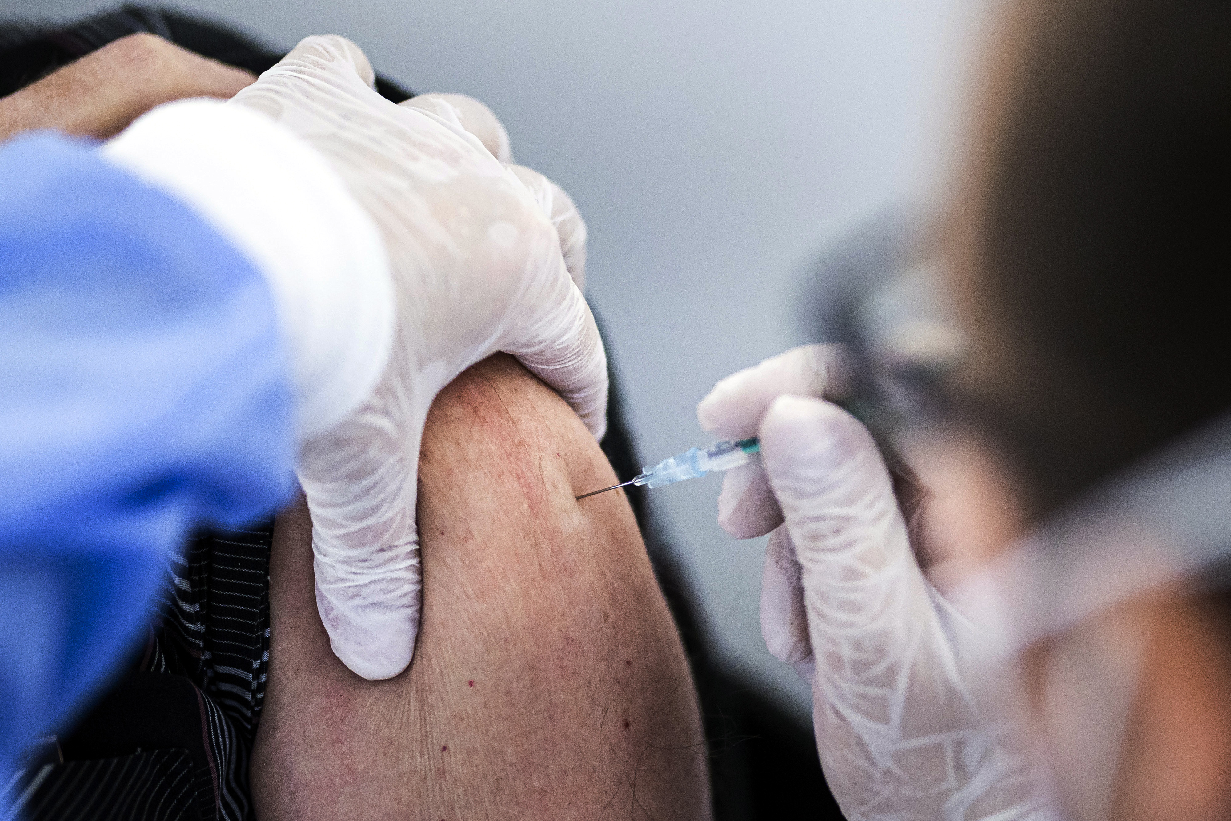 Vaccination against Covid-19: Close-up of the injection of the vaccine into the upper arm of a woman.