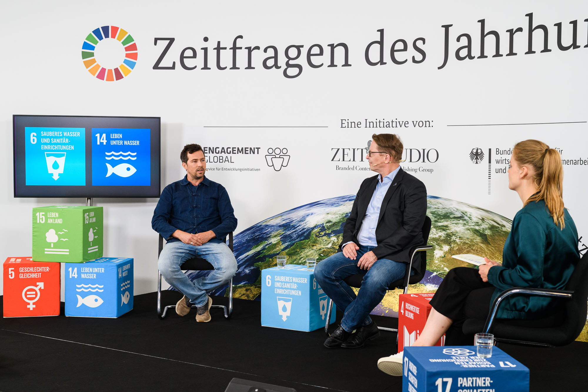 Von links: Tobias Rau, Geschäftsführender Vorstand bei Viva con Agua, Jörg-Andreas Krüger, Präsident des Naturschutzbundes Deutschlands (NABU) und die Moderatorin Sabine Pusch bei der Diskussion zu den SDGs 6 und 14