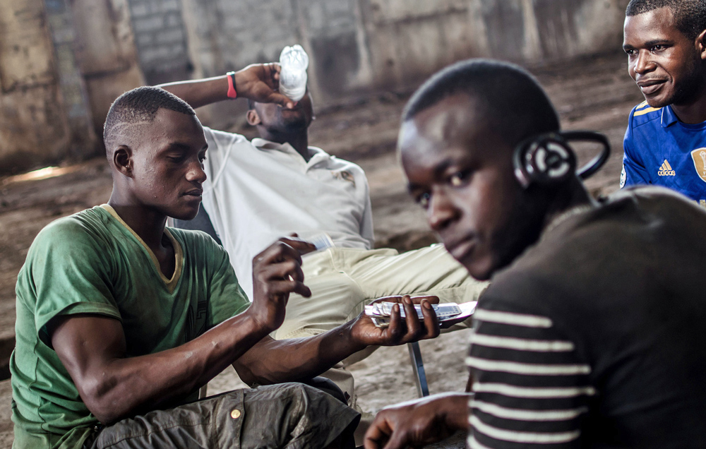 In einem verlassenen Lagerhaus in Conakry, Guinea, spiele junge arbeitslose Männer Karten.