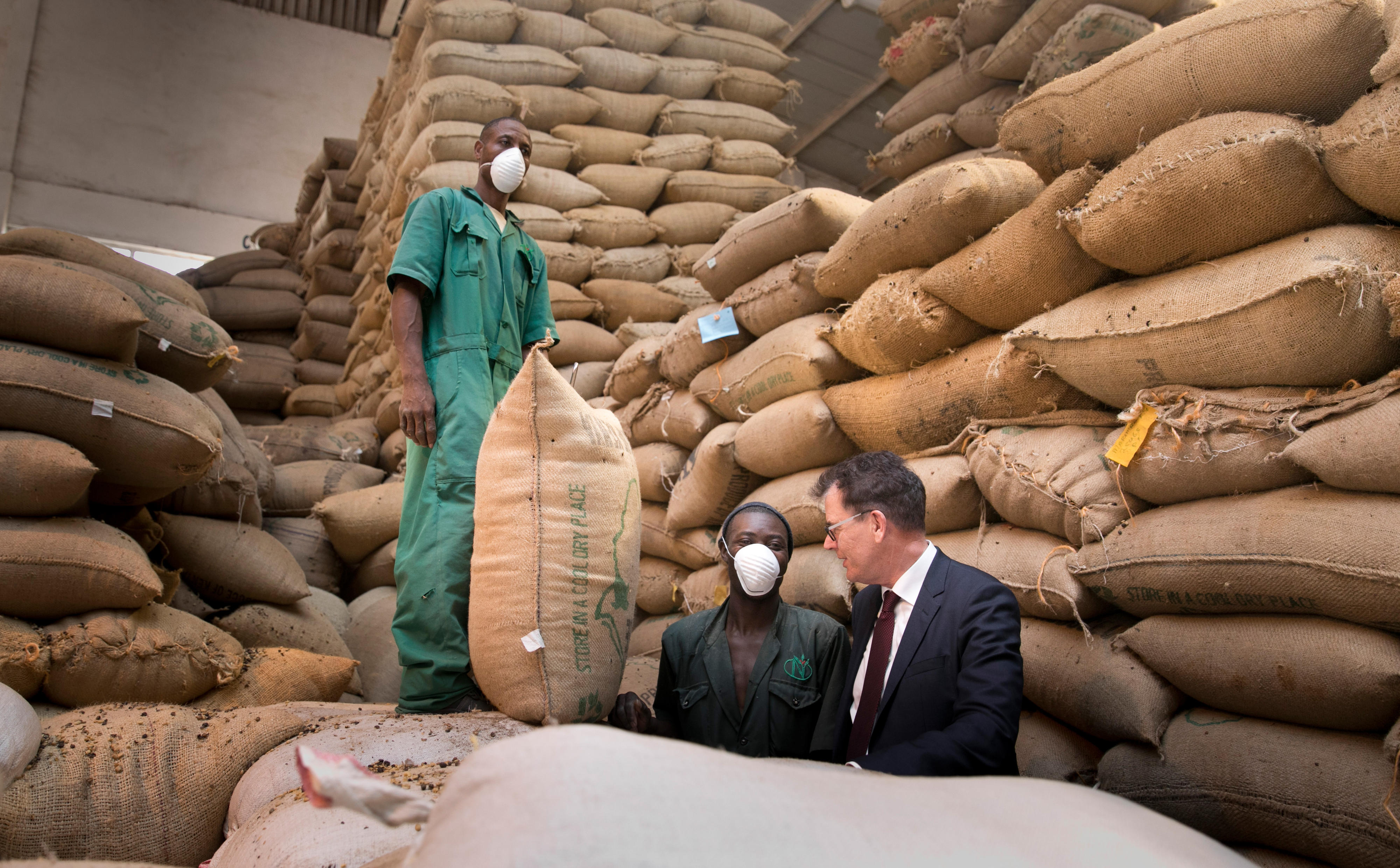 Minister Gerd Müller spricht mit Arbeitern der größten Kaffeerösterei von Kenia in Thika.