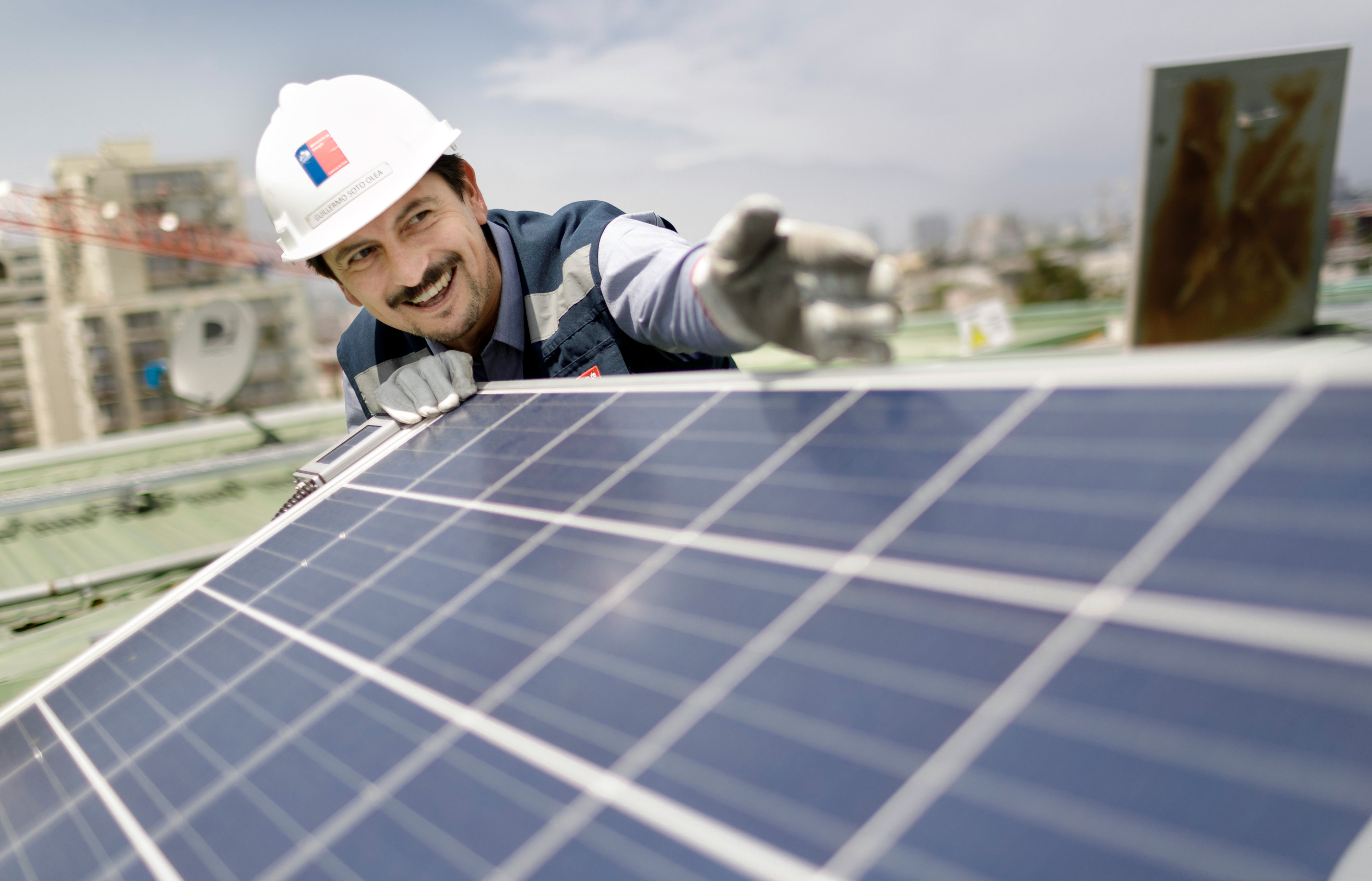 A worker checks a solar installation on a roof in Santiago de Chile.