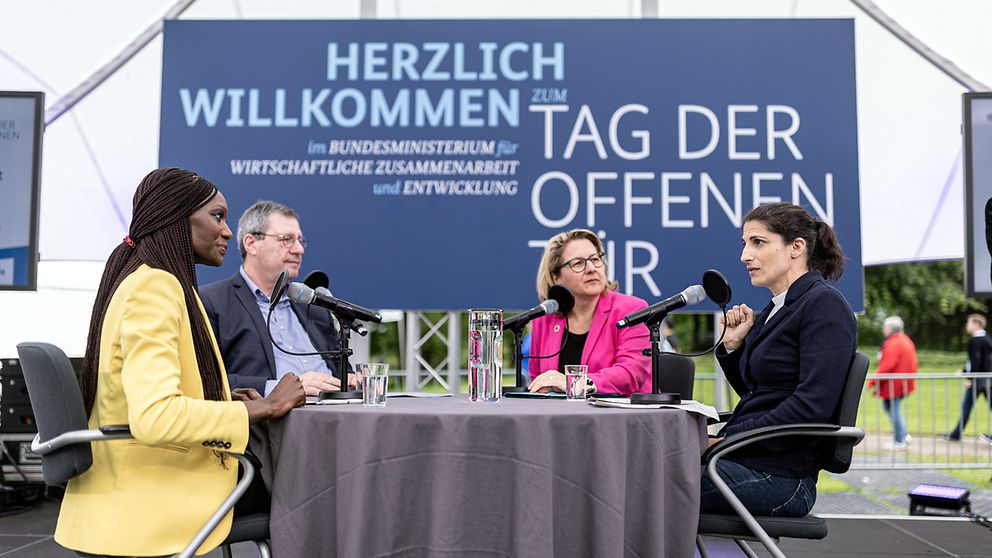 Live-Podcast „Entwicklungssache“ zu Nachhaltigkeit im Fußball und zur Europameisterschaft 2024 mit (von links) Moderatorin Liz Shoo, Werner Wolf (Präsident 1. FC Köln), Bundesentwicklungsministerin Svenja Schulze und Riem Hussein (DFB-Schiedsrichterin) 